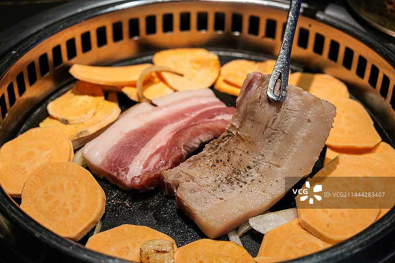 韩式烧烤烤猪五花肉夹子夹烤五花肉特写图片素材