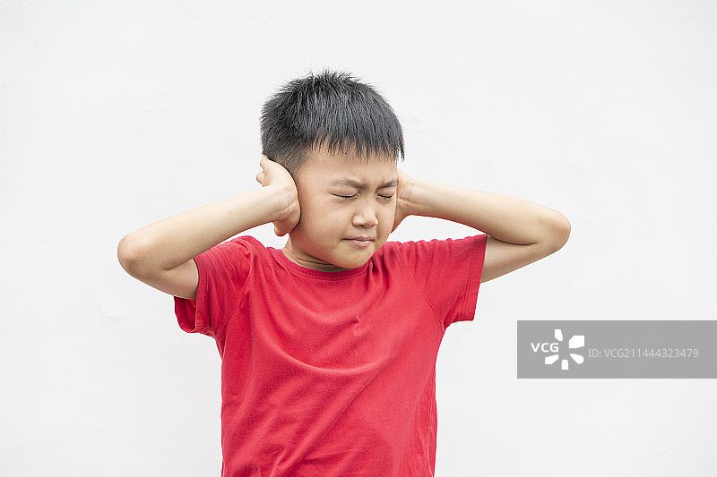 白色背景中捂住耳朵的小男孩图片素材