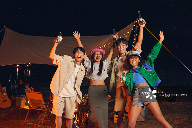 四人夜晚露营欢呼图片素材