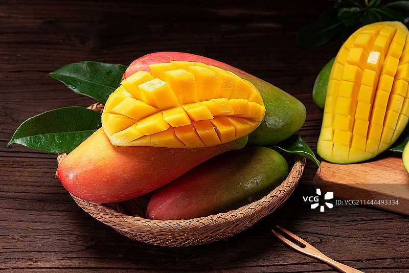 乡村风格暗调旧木板背景上的新鲜芒果图片素材