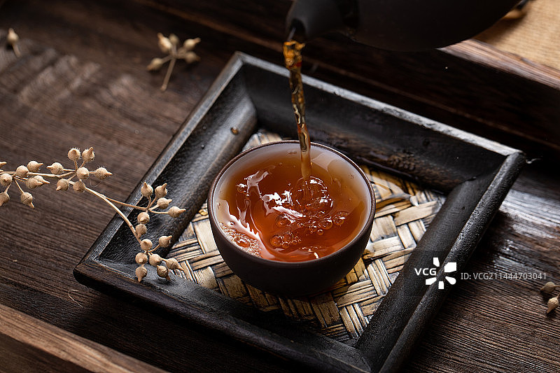 中式茶具场景中往茶杯中倒茶图片素材