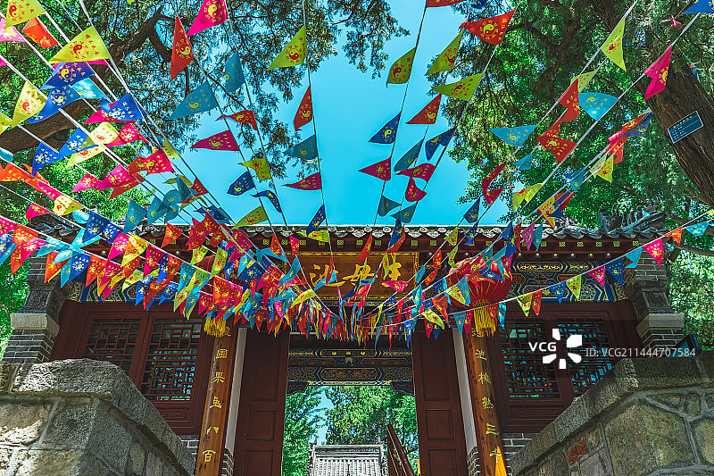 中国寺庙宗教用品拍摄主题，王母池正门随墙门，低视角仰拍阴阳八卦乾坤道教龙纹旗 五色旗 ，户外白昼无人图片素材