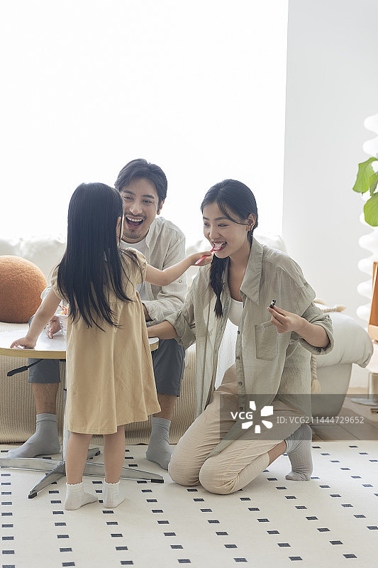 幸福一家三口在客厅吃冰淇淋图片素材