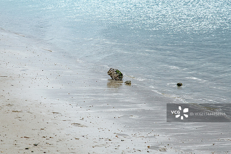 沙滩上的石头与透明的蓝色海水海浪 关岛杜梦湾海滩图片素材