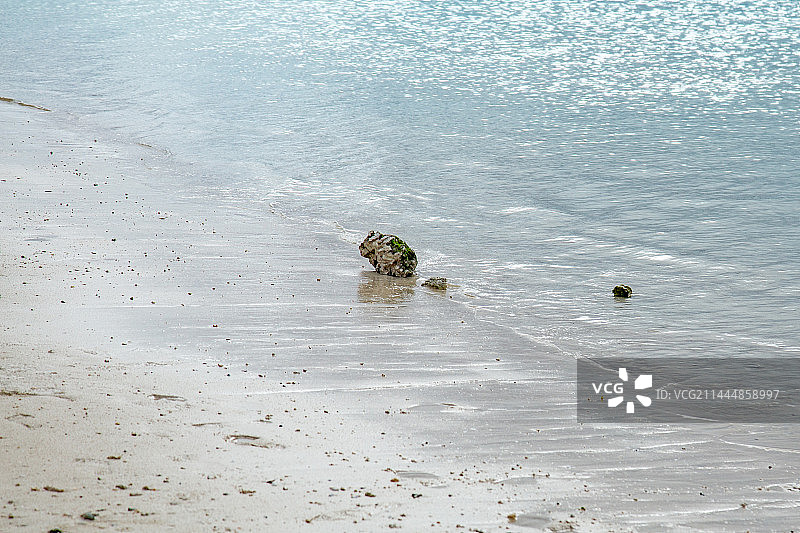 沙滩上的石头与透明的蓝色海水海浪 关岛杜梦湾海滩图片素材