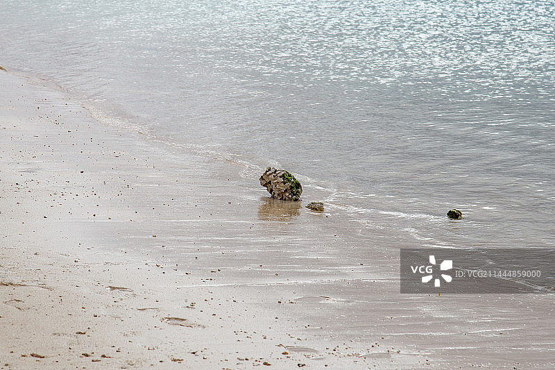 沙滩上的石头与透明的蓝色海水海浪 关岛杜梦湾海滩图片素材