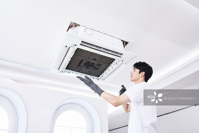 夏季生活：韩国亚洲青年组装空调图片素材