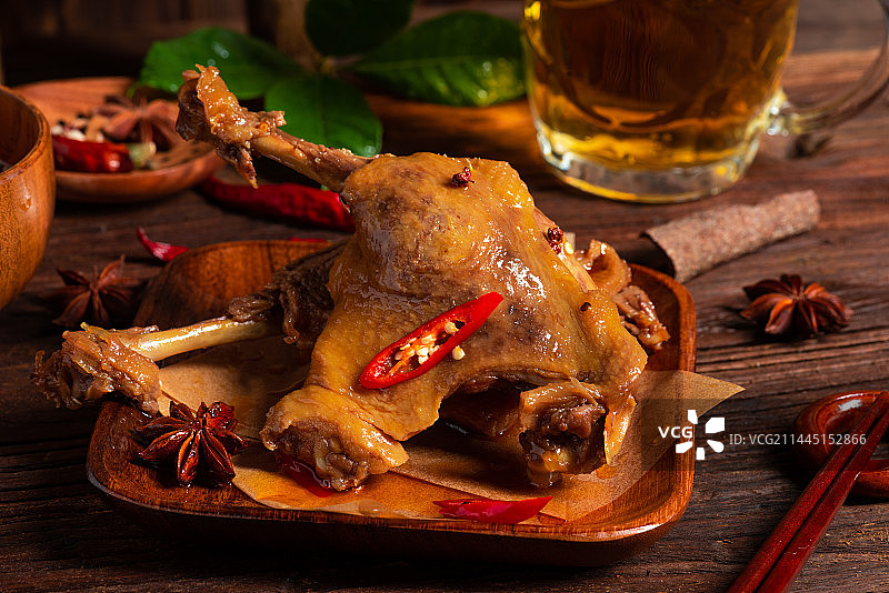 乡村风格美食摄影旧木板上的卤制大鸭腿肉特写图片素材