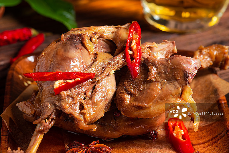 乡村风格美食摄影旧木板上的卤制大鸭腿肉特写图片素材