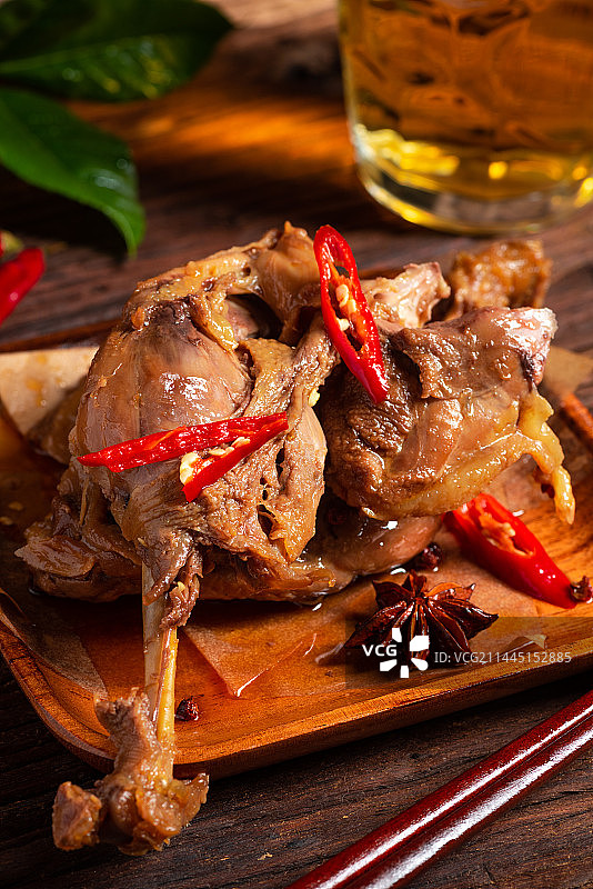 乡村风格美食摄影旧木板上的卤制大鸭腿肉特写图片素材
