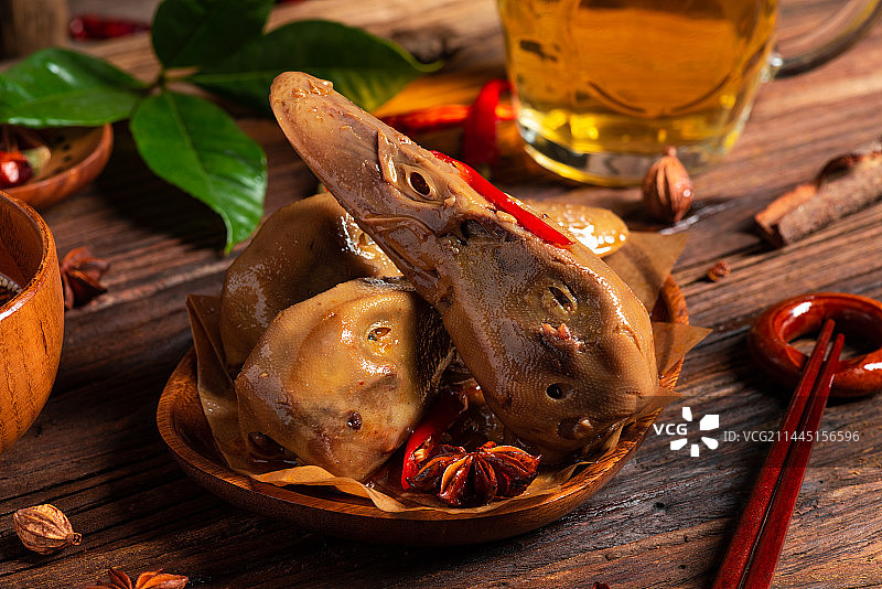 乡村风格美食摄影旧木板上的卤水鸭头特写图片素材