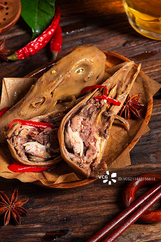 乡村风格美食摄影旧木板上的卤水鸭头特写图片素材
