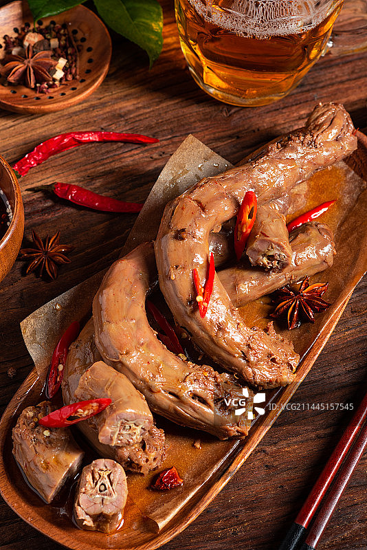 乡村风格美食摄影旧木板上的诱人热卤现捞卤水鸭脖特写图片素材
