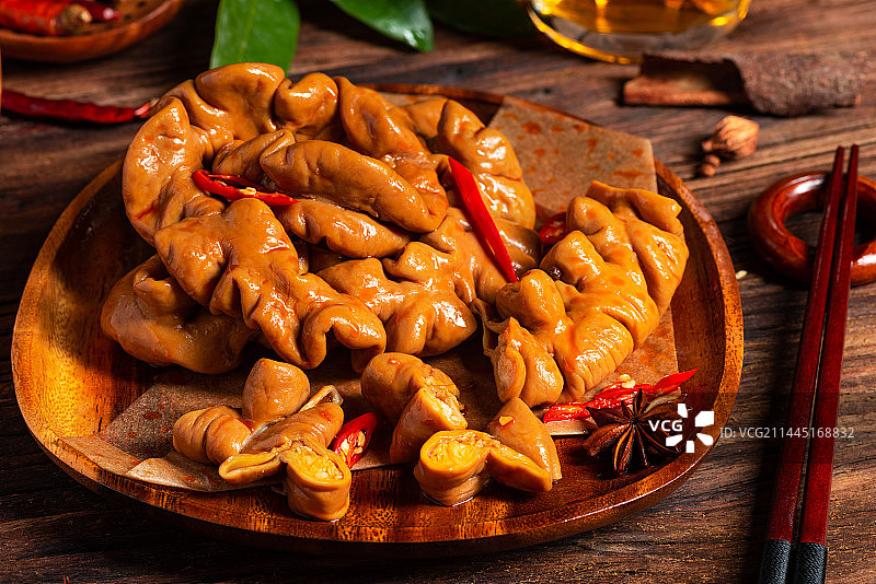 乡村风格美食摄影旧木板上诱人的卤肥肠特写图片素材