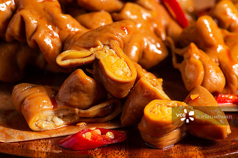 乡村风格美食摄影旧木板上诱人的卤肥肠特写图片素材