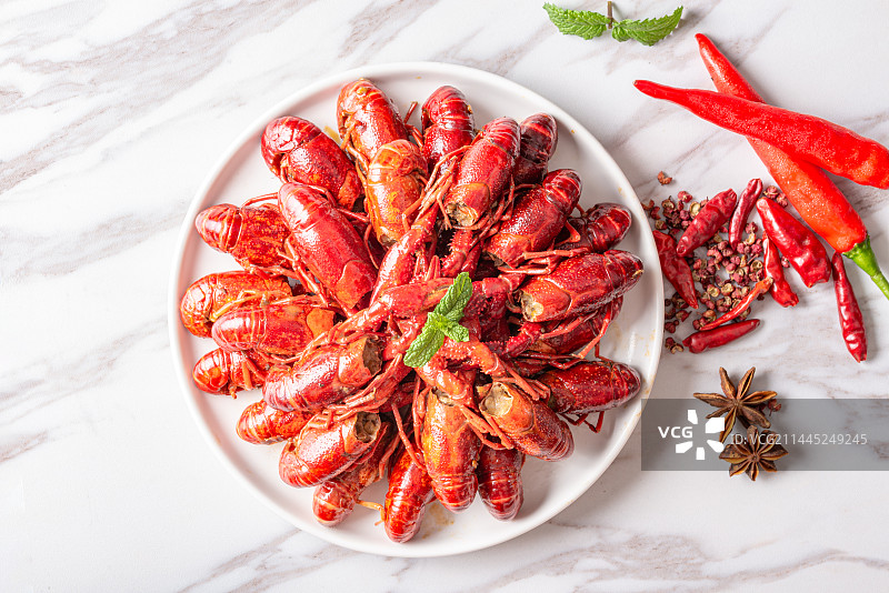 木纹桌面上白色瓷碗里的小龙虾图片素材