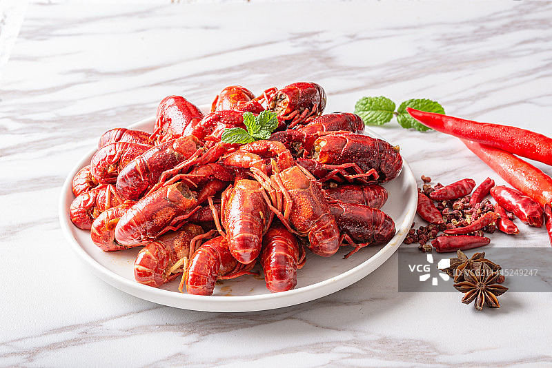 木纹桌面上白色瓷碗里的小龙虾图片素材