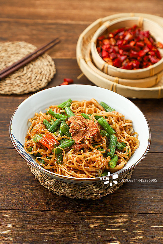 放在桌子上的猪肉豆角焖面图片素材
