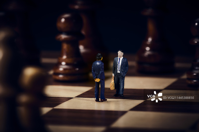 棋盘上西装革履的迷你娃娃彼此相对图片素材