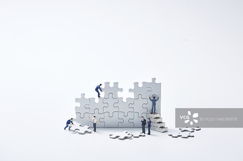 多个微型玩偶组装白色拼图图片素材