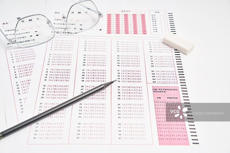 考试答题卡上放着一支笔和眼镜图片素材