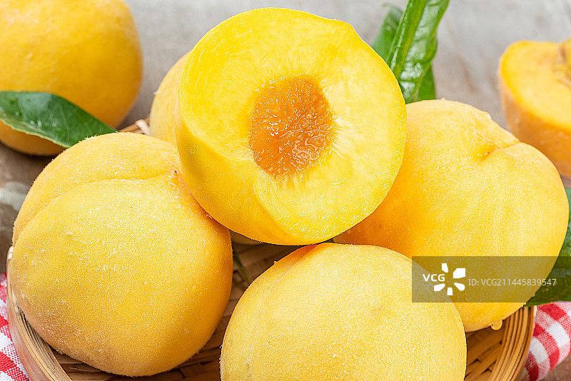 旧木板上的一大盘新鲜黄桃特写图片素材