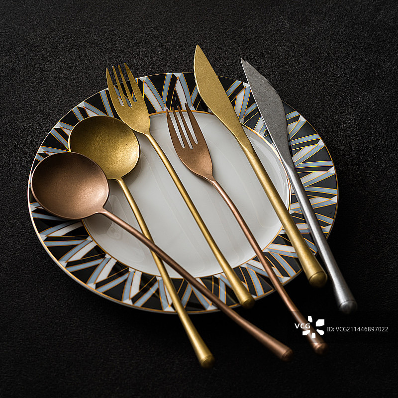 餐桌上的金色铜色不锈钢刀叉勺图片素材