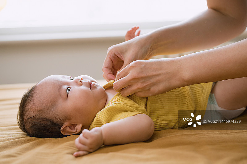 妈妈给小男孩换衣服图片素材
