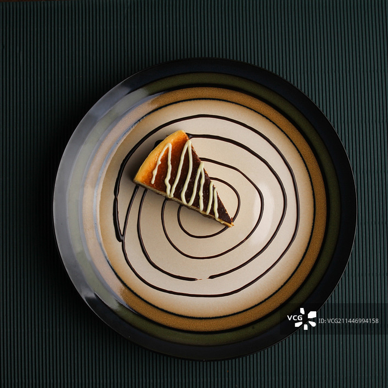 放在圆盘上的芝士蛋糕淋着巧克力酱图片素材