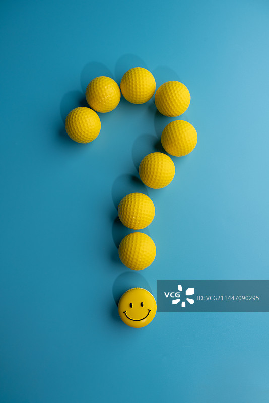 正上方蓝色背景的黄色小球组成的问号和笑脸微缩创意图片素材