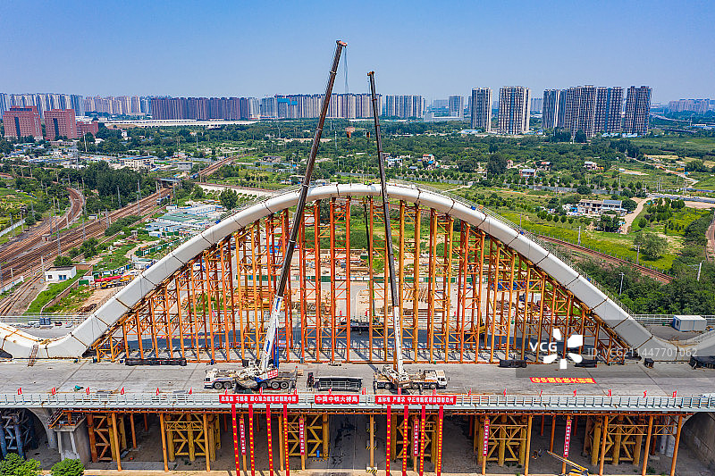 航拍河南郑州新建彩虹桥钢箱拱合龙 跨越郑州北站铁路编组站桥梁 大桥施工建设 拱桥吊装图片素材