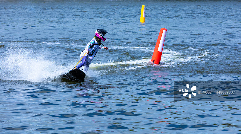 一个人在玩水上极限运动电动冲浪板，浪花四溅图片素材