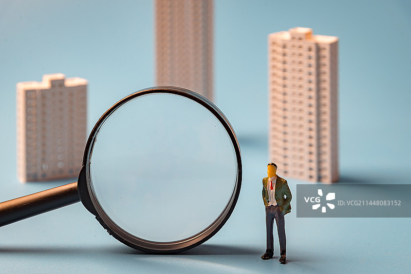楼房模型 放大镜 商务人偶：楼市政策 住房政策 楼市 房地产概念图片图片素材
