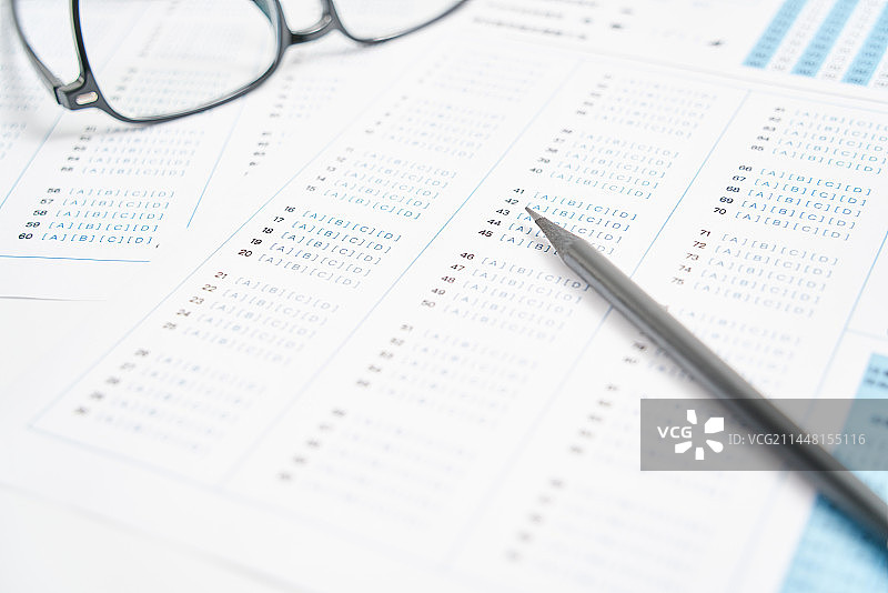 考试答题卡上放着一支笔和眼镜图片素材