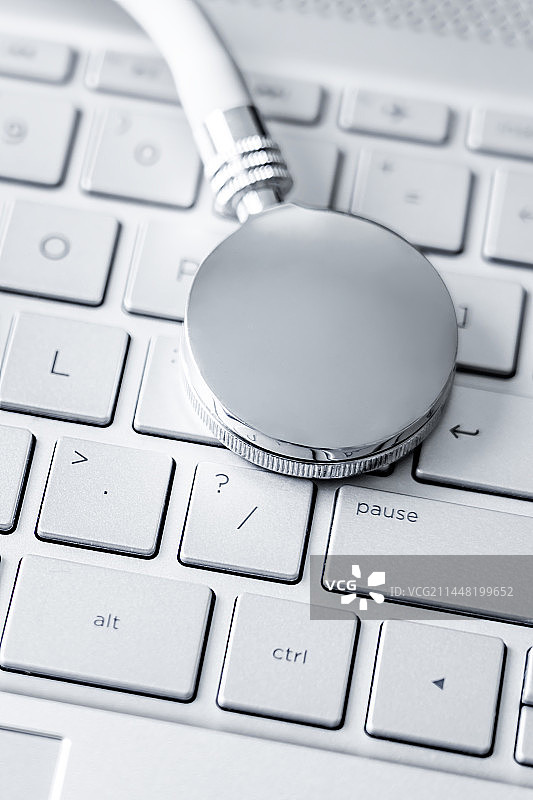 听诊器放在银色电脑键盘上——健康医疗概念图片素材