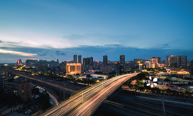 广东省茂名市茂南区高架桥与高铁轨道交汇蓝调夜景日落列车经过图片素材