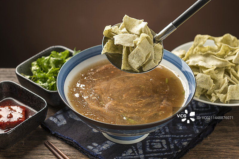 天津传统早餐锅巴菜摆放在木桌面上特写图片素材