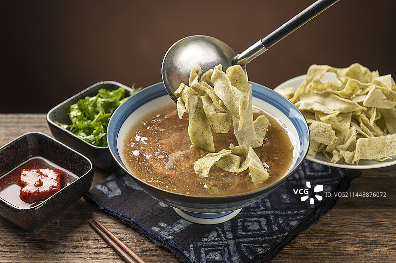 天津传统早餐锅巴菜摆放在木桌面上特写图片素材