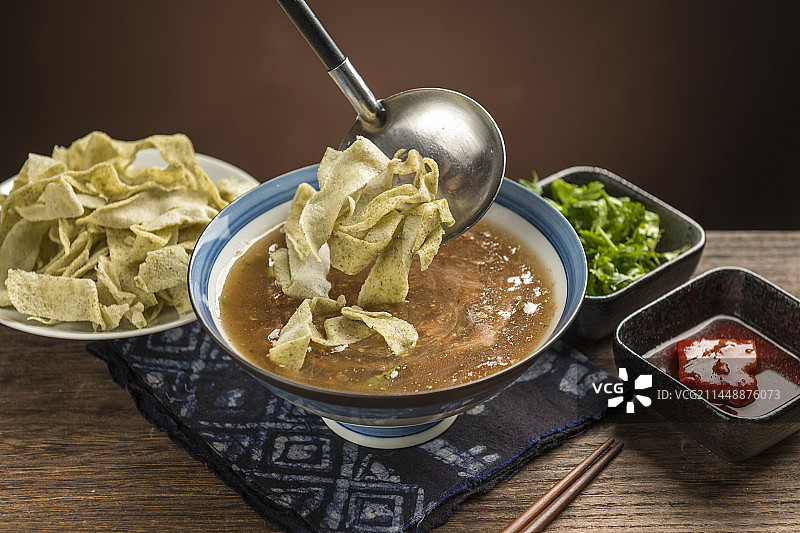 天津传统早餐锅巴菜摆放在木桌面上特写图片素材