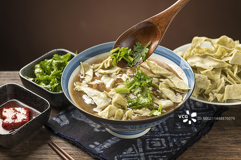 天津传统早餐锅巴菜摆放在木桌面上特写图片素材