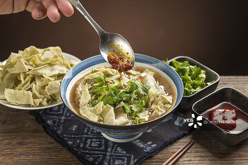 天津传统早餐锅巴菜摆放在木桌面上特写图片素材