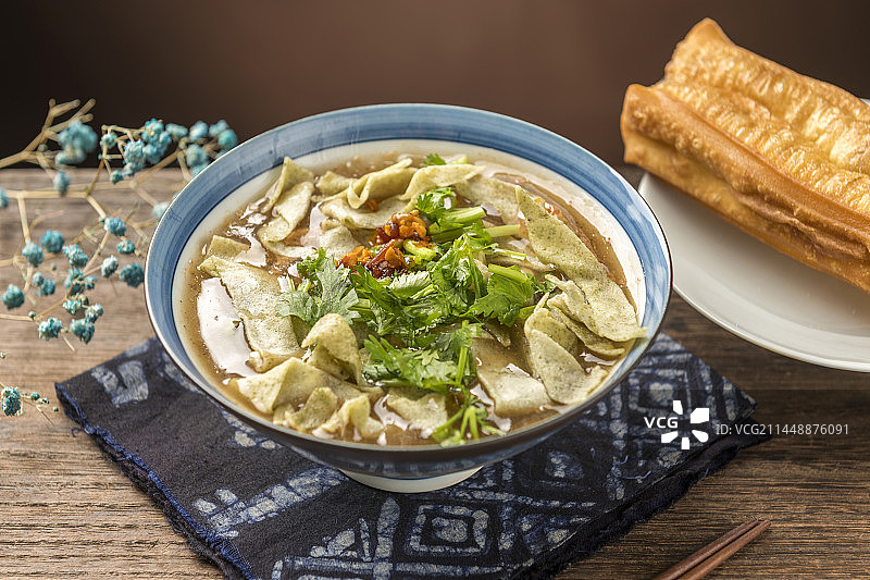 天津传统早餐锅巴菜摆放在木桌面上特写图片素材