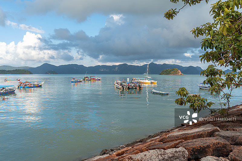 湖边堤岸，小船与远处小岛群山图片素材