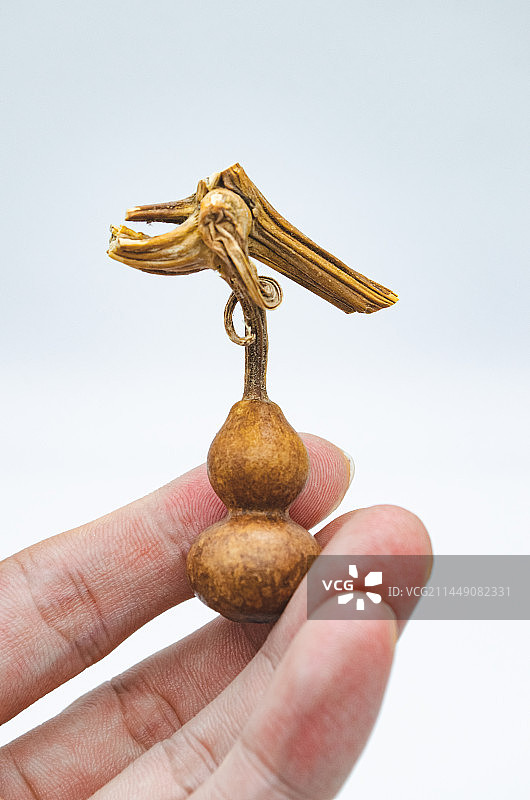 中国文玩拍摄主题，一个花皮脏皮的手捻盘玩的文玩八宝葫芦和龙头龙须，室内无人影棚拍摄图像摄影图片素材