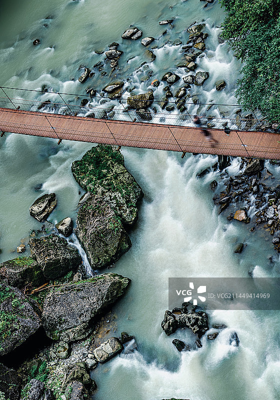 河流流经岩石与索桥的高角度视图：重庆黔江蒲花暗河景区图片素材