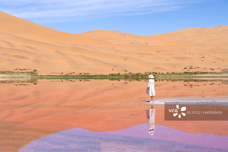 女性游客在中国西部内蒙古阿拉善右旗巴丹吉林沙漠粉红湖的旅拍写真图片素材