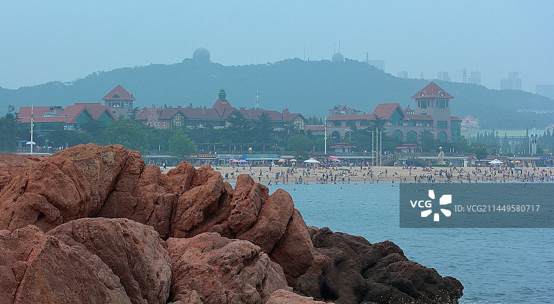 以城市沙滩为背景的海洋与礁石图片素材