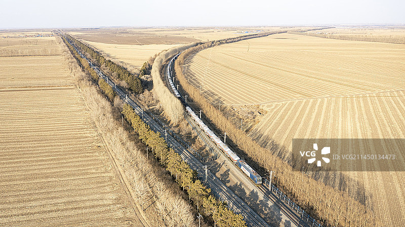 HXD3B机车牵引货车行驶在早春的京哈线上图片素材