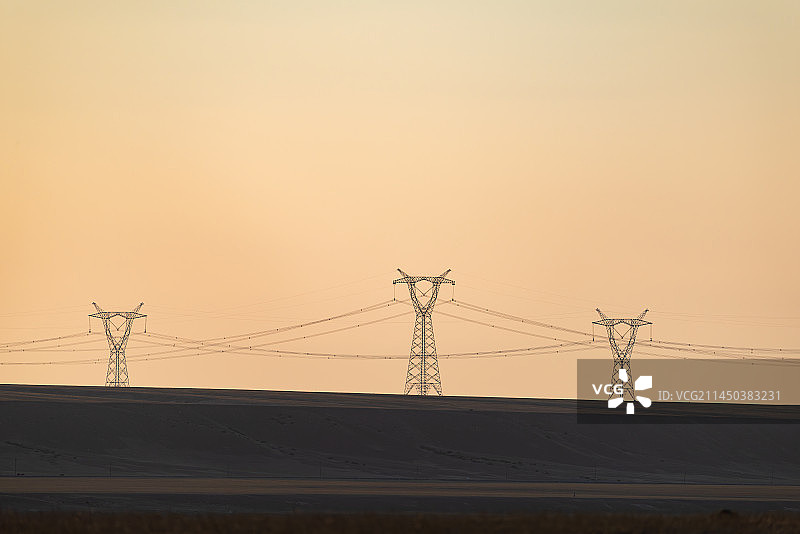 新疆克拉玛依独山子区夕阳下的电力铁塔风光图片素材