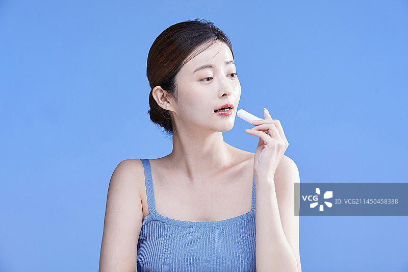 韩国美女手持唇膏的概念照片图片素材